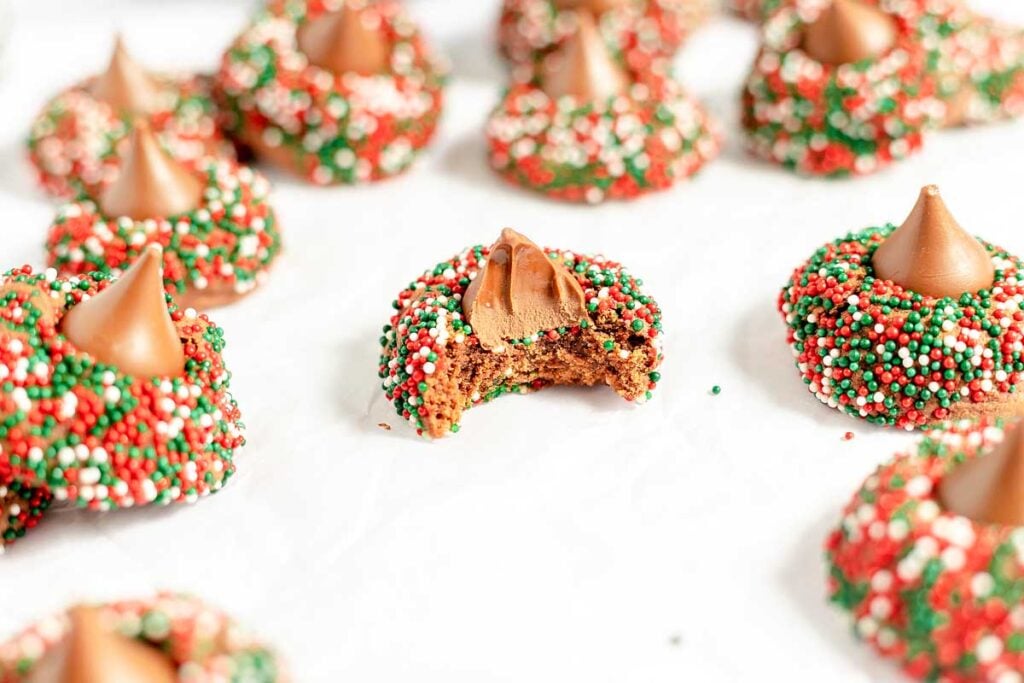A group of colourful cookies with sprinkles on top.