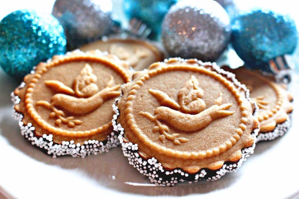 A plate with gingerbread cookies and ornaments on it.