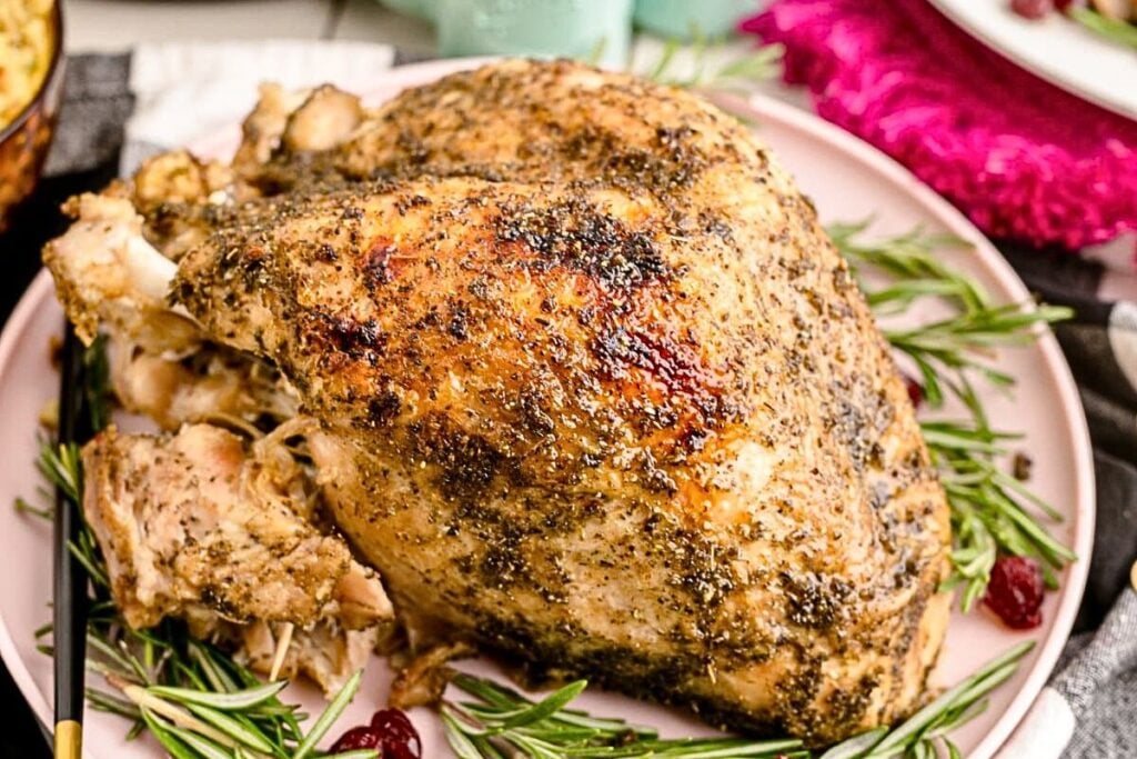 A herby turkey breast on a platter.