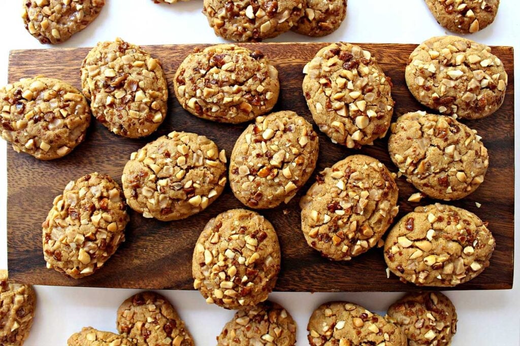 Nutty peanut butter cookies on a wooden cutting board.