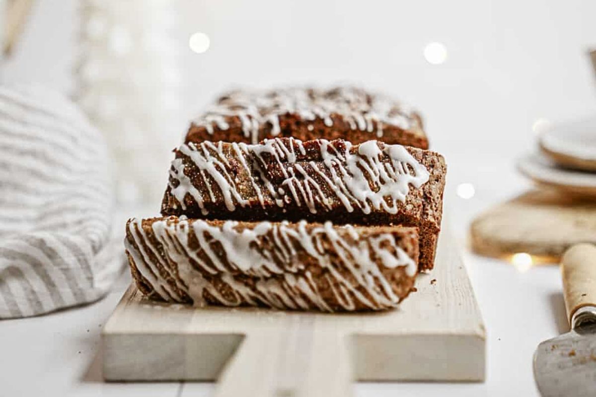 A gingerbread loaf cake sliced and drizzled with icing.