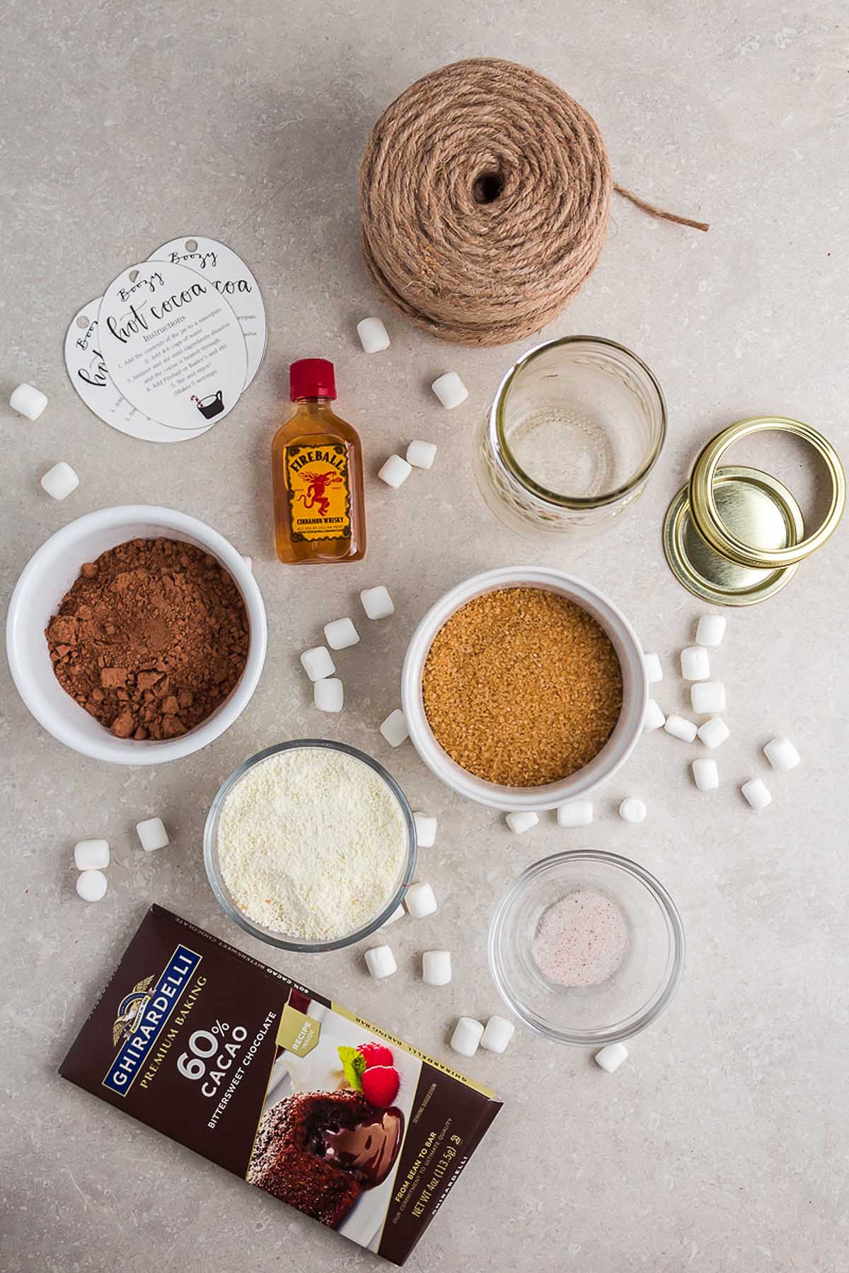 A handmade Christmas gift of a hot chocolate gift kit is displayed on a table, with all the ingredients for a delicious chocolate cake.