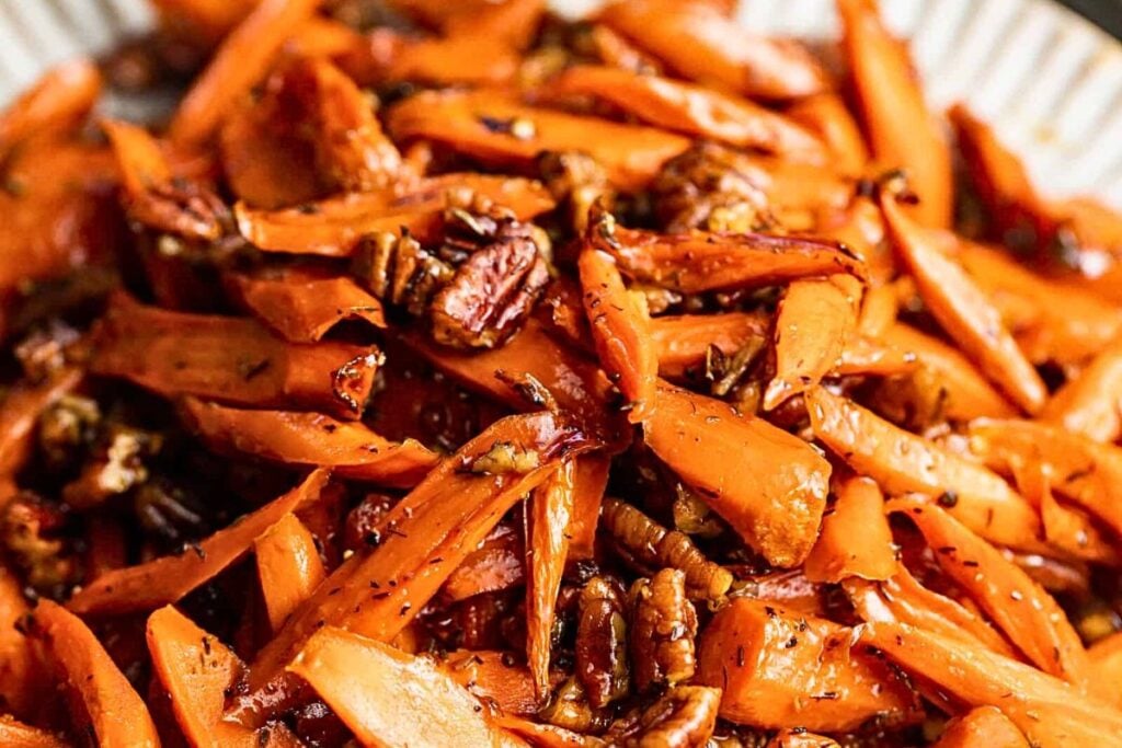 A platter of honey glazed carrots wit pecans.