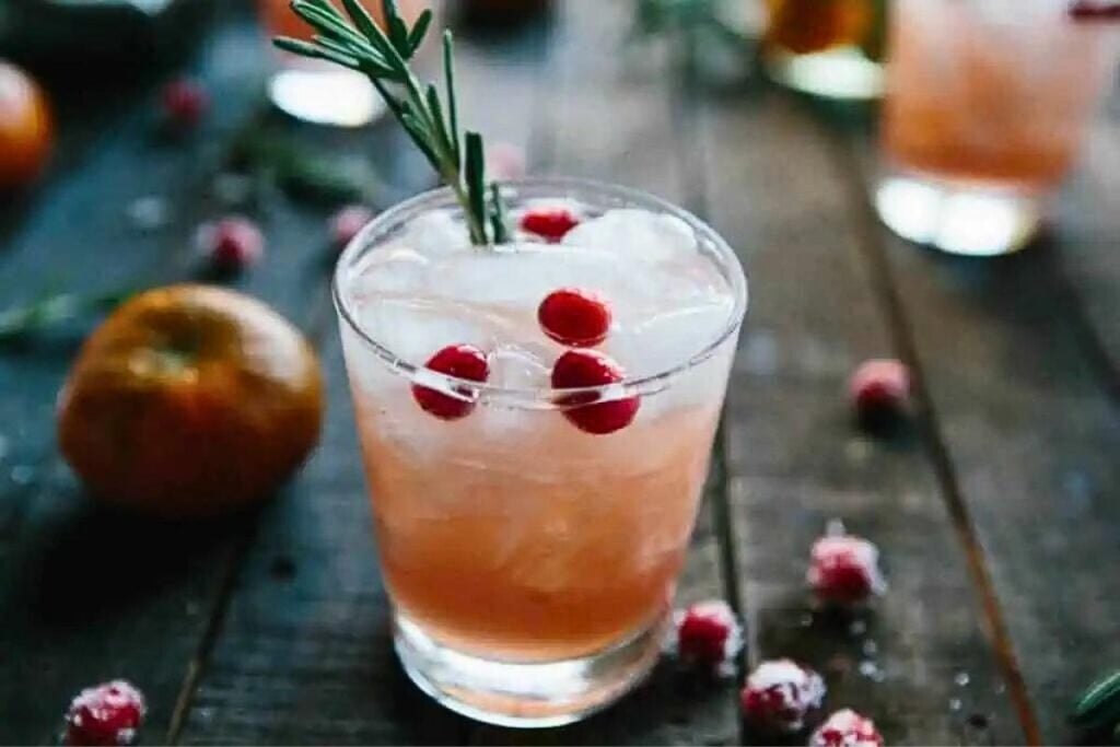 Glasses of cocktails with cranberry, clementine and pomegranate pearls. 