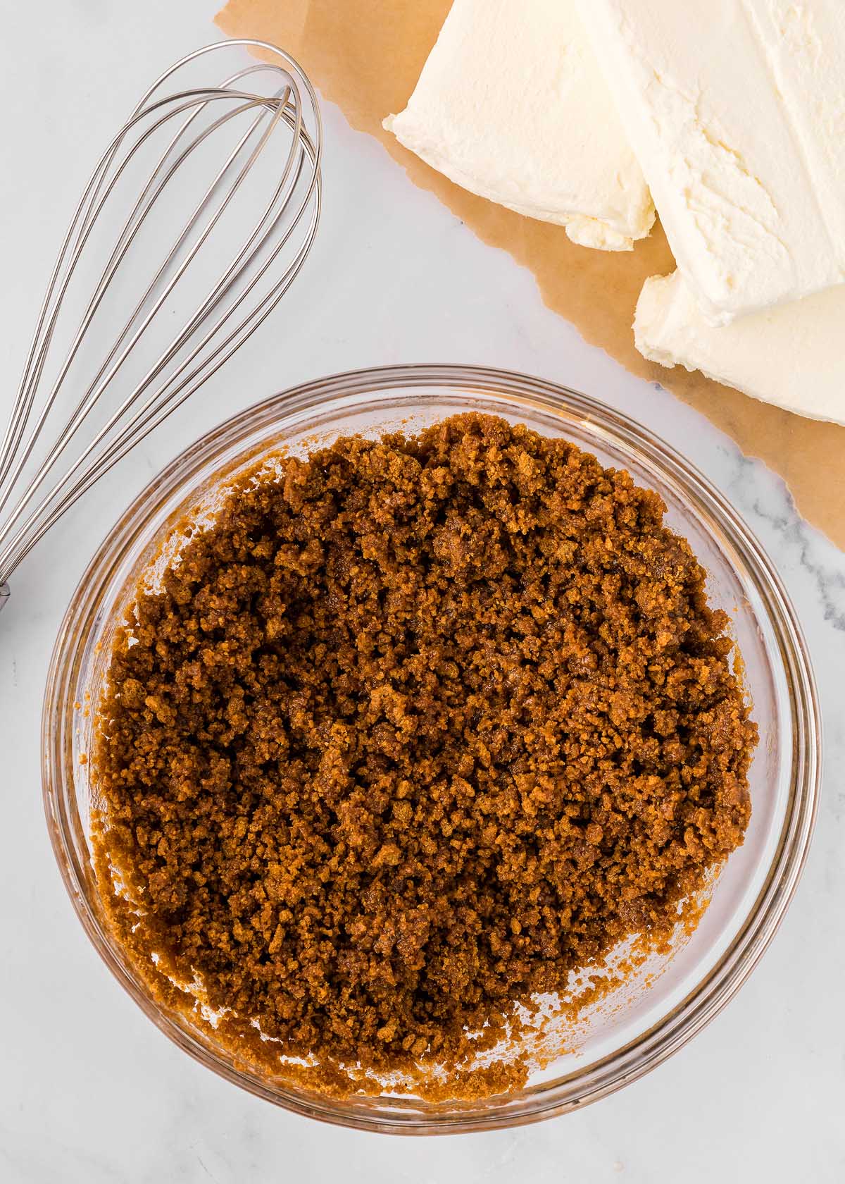 A glass bowl with a whisk, ready to prepare an eggnog dessert.