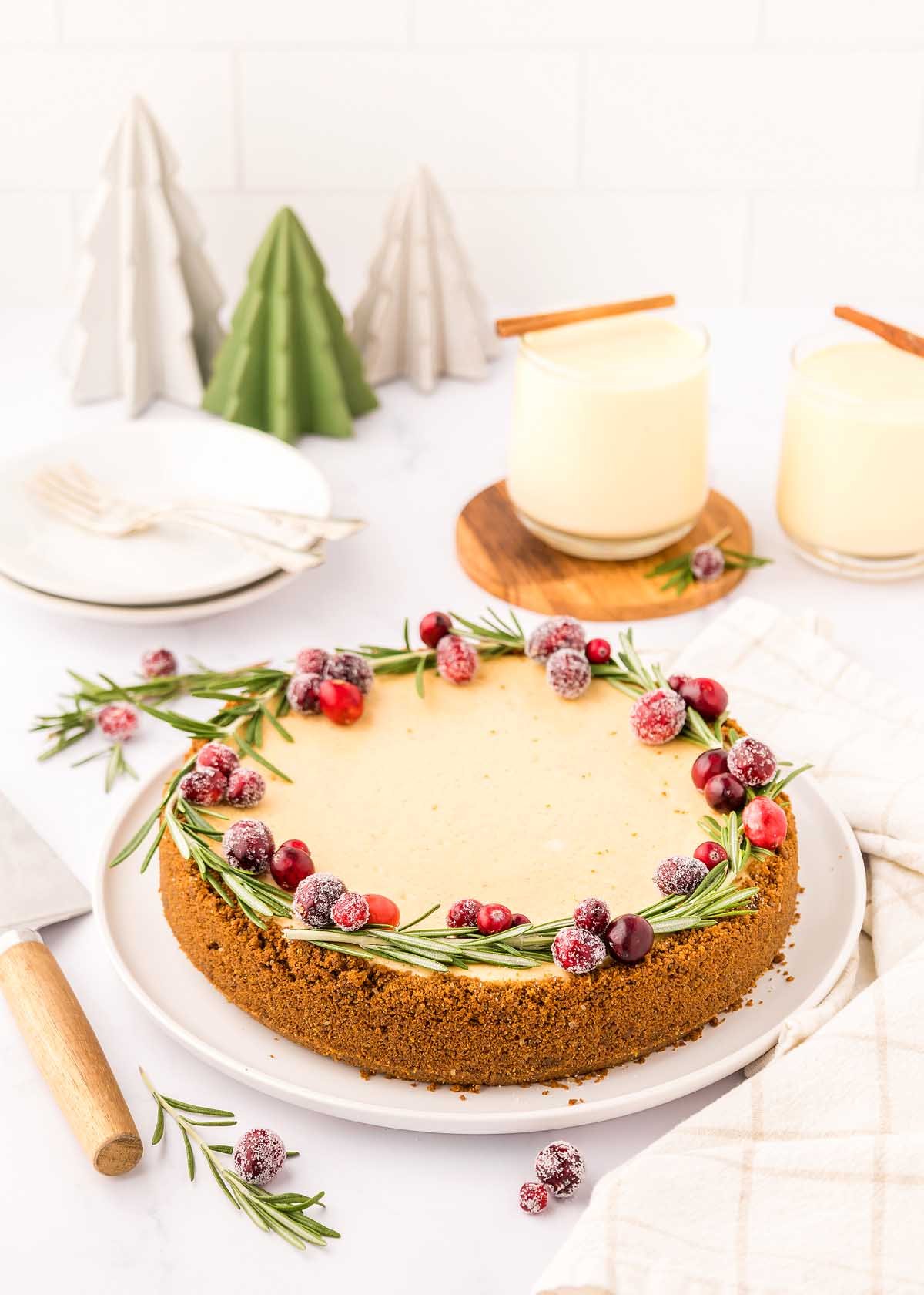 A gingerbread cheesecake with cranberries on a festive dessert plate.
