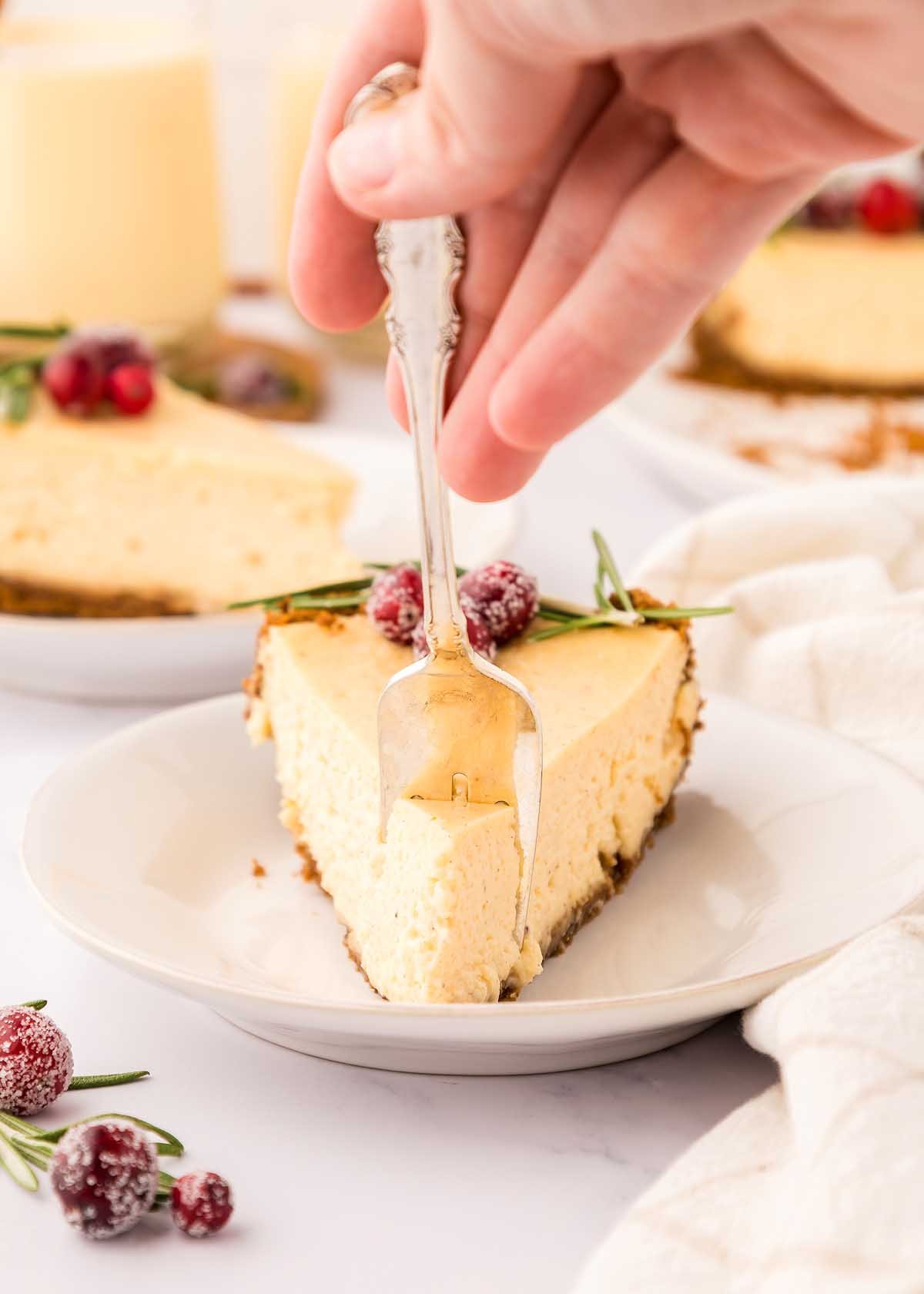 A festive dessert, eggnog cheesecake, with cranberries on a plate.