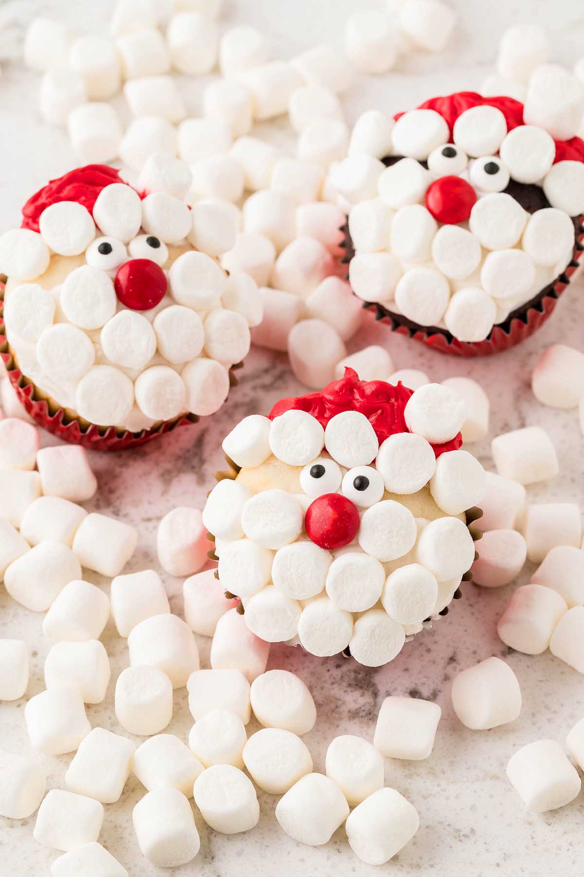 Christmas cupcakes adorned with marshmallows and Santa Claus, perfect for those seeking Santa themed treats.