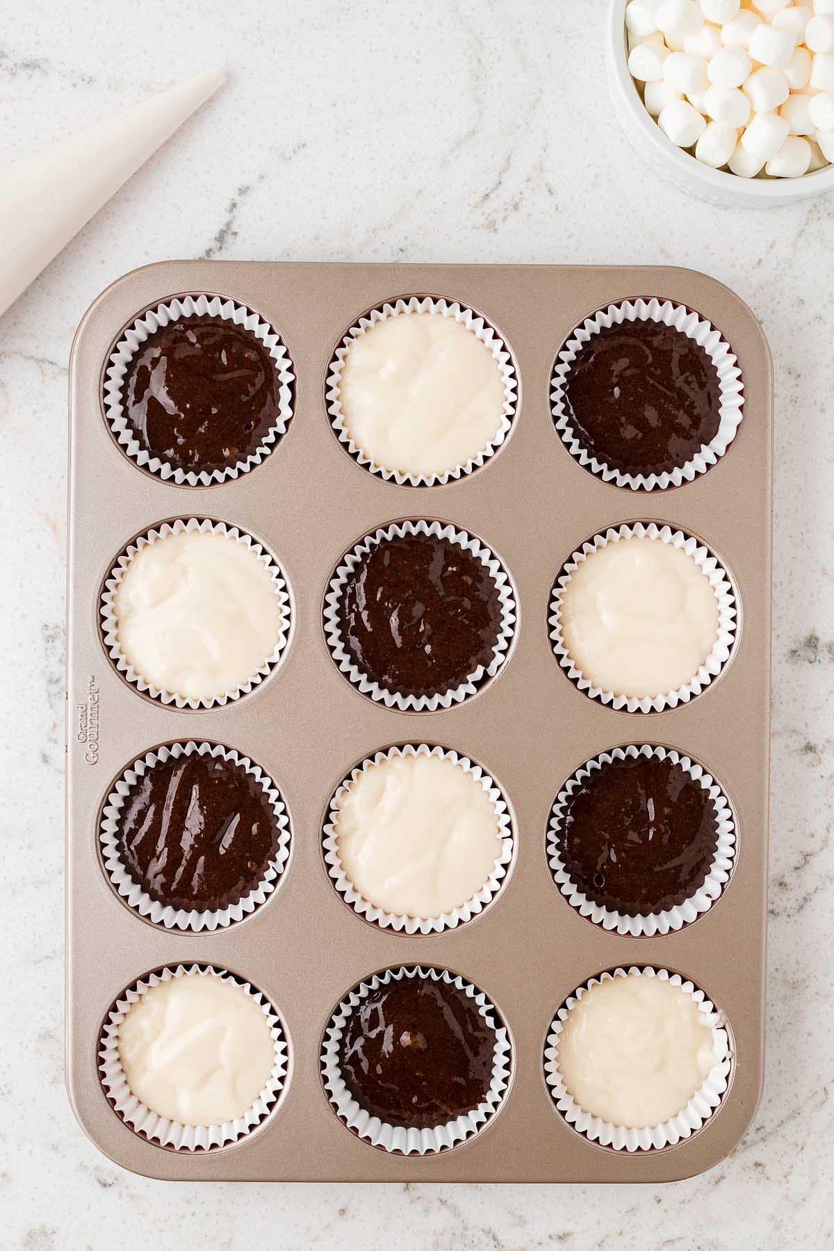 White and chocolate cupcakes decorated like Santa's face in a muffin tin.