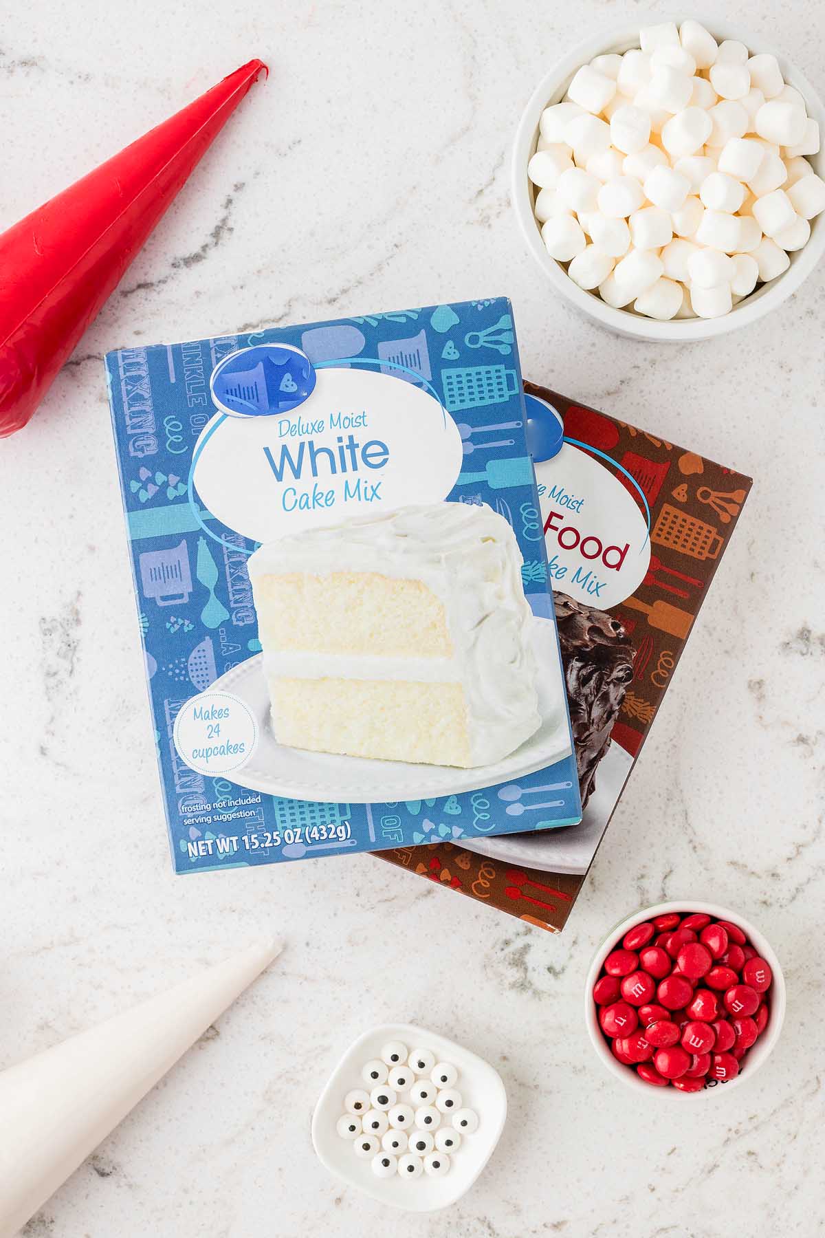 A white cake with sprinkles and marshmallows on a table, perfect as a Christmas cupcake or for those who love Santa-themed treats.