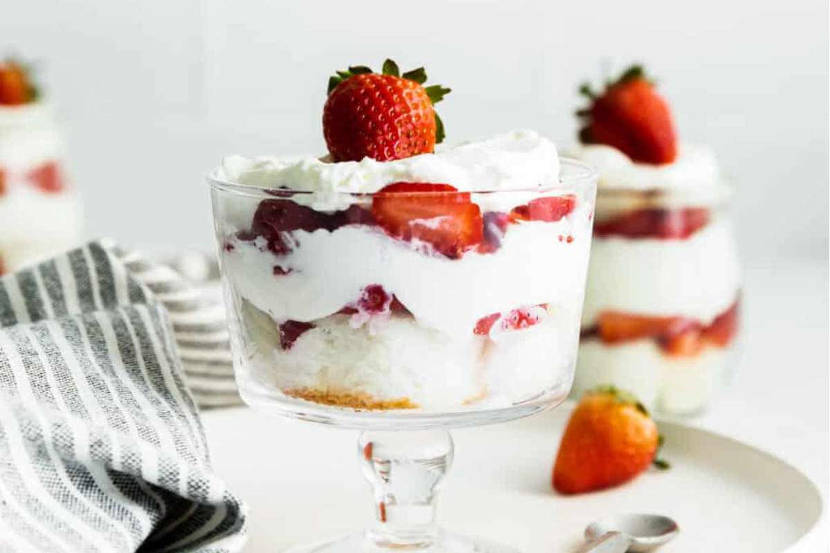 Strawberry trifles in jars with whipped cream and strawberries.
