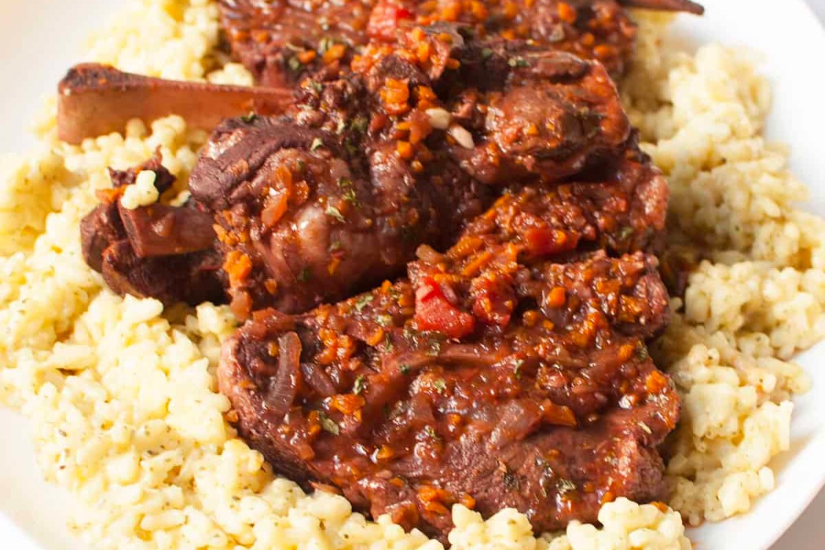 A plated New Year's dinner featuring couscous and succulent meat on a pristine white plate.