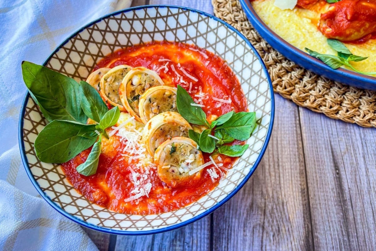 A bowl of tomato soup alongside a bowl of gnocchi on a table, creating a delightful feast of Italian flavors.