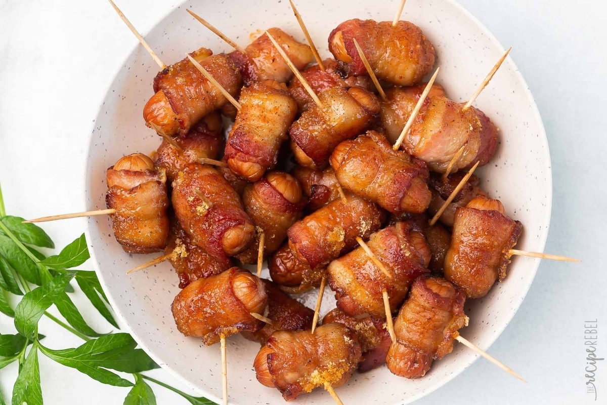 NYE appetizers featuring bacon wrapped skewers on a white plate.