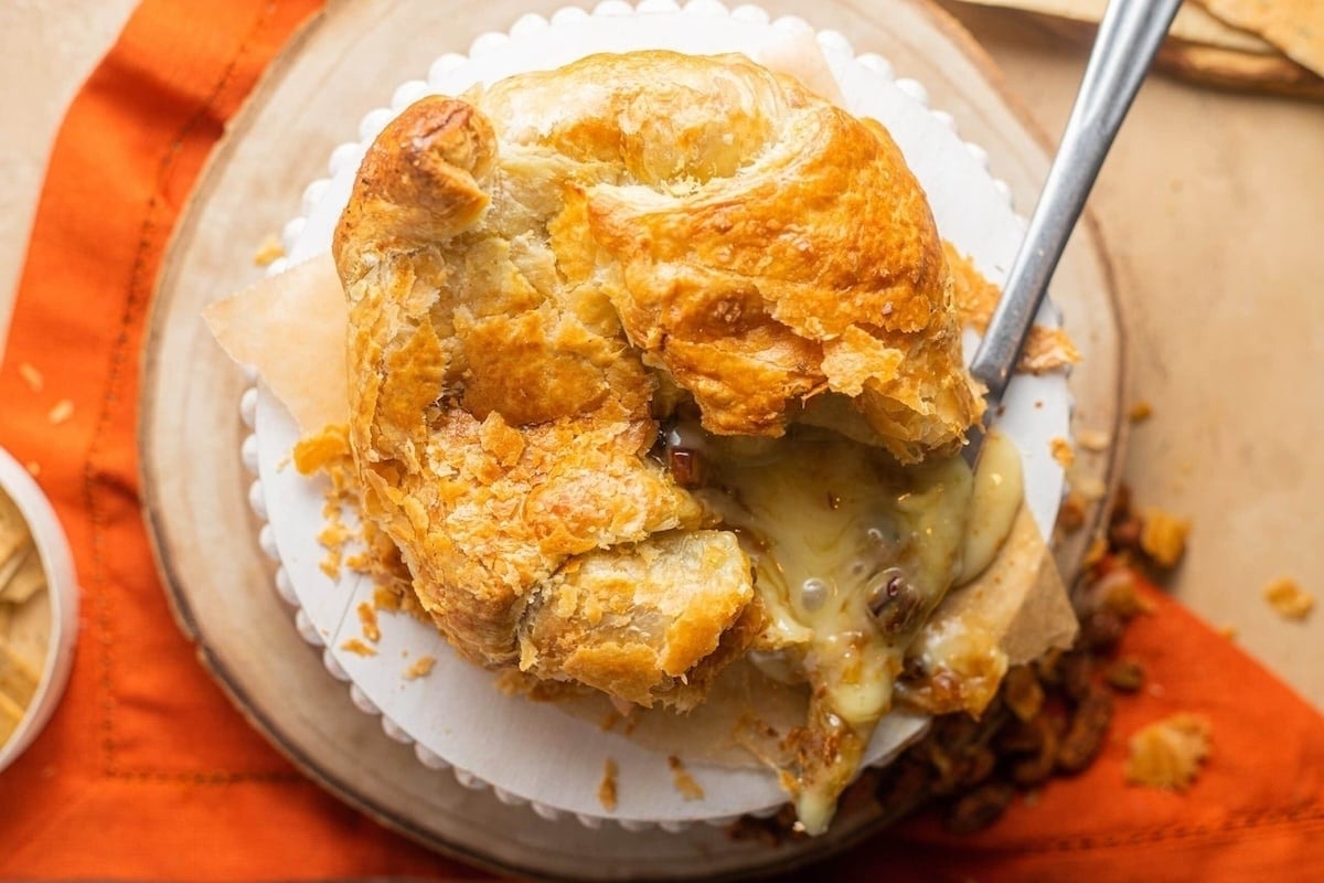 A delicious pie adorned with cheese and bacon, served elegantly on a plate at a delightful New Year's Eve party.