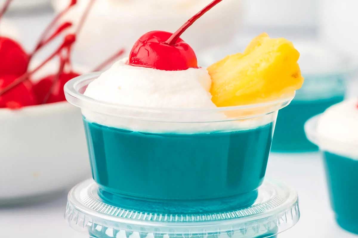 A blue and white dessert with whipped cream and a cherry on top, perfect for jello shots.