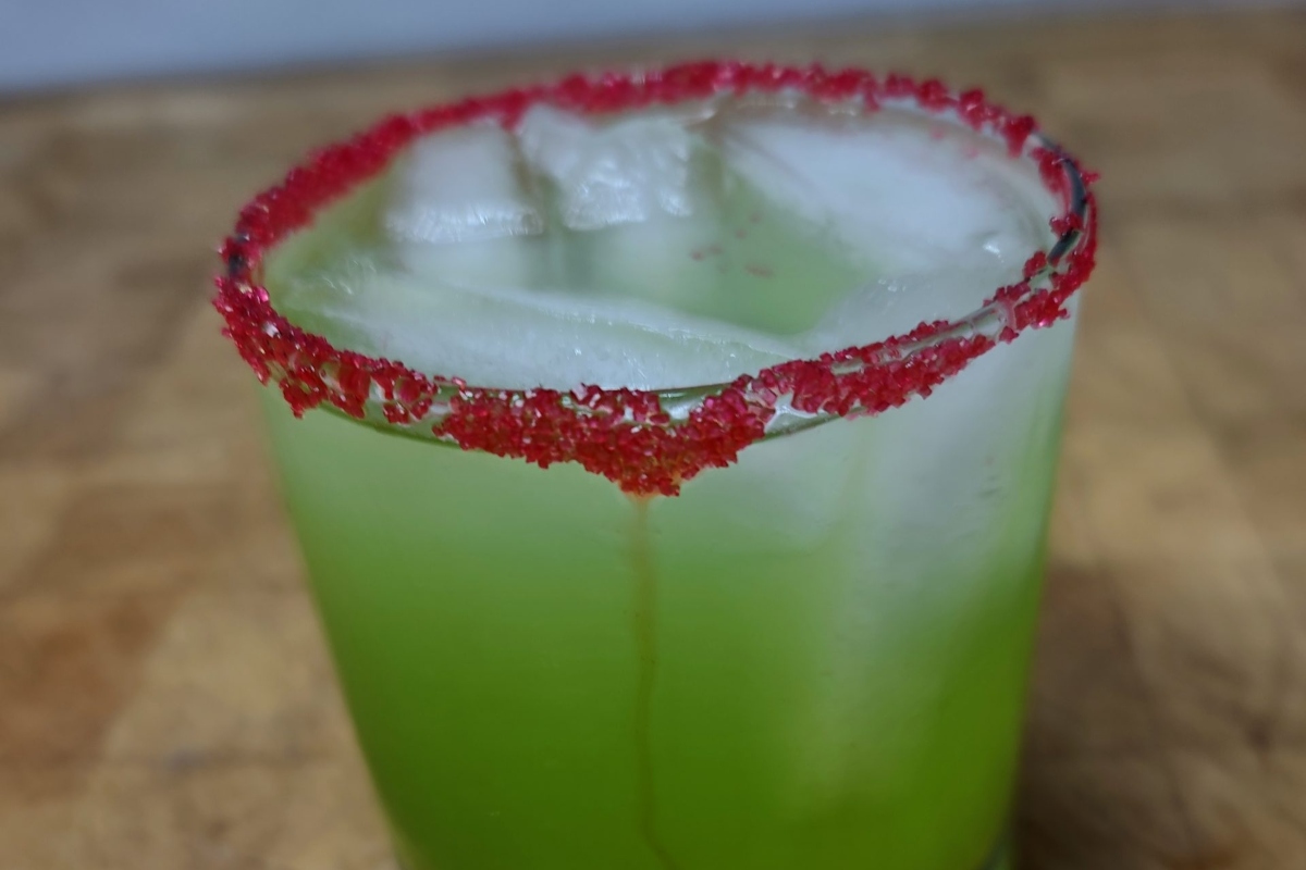 A festive green drink with red sprinkles on top, perfect for Christmas.