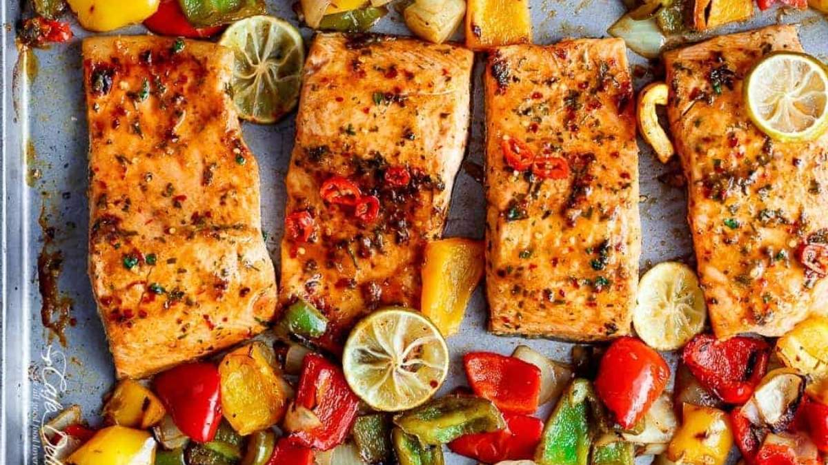 Grilled salmon and vegetables on a baking sheet.