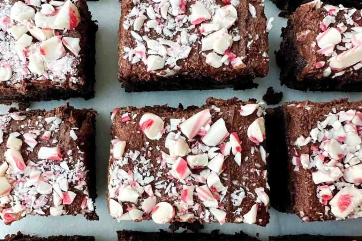 Peppermint brownies sprinkled with candy cane bits on a white plate.
