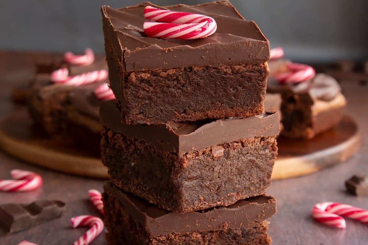 A stack of chocolate brownies topped with candy canes.