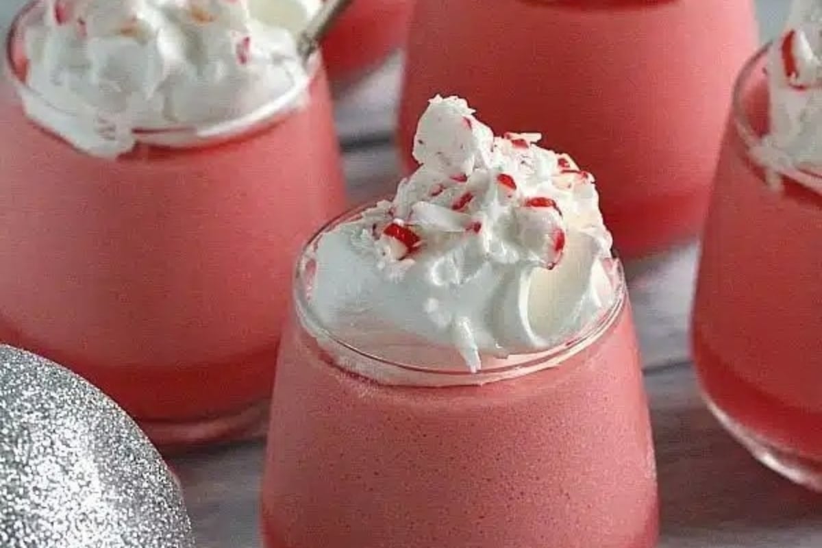 Decadent pink peppermint milkshakes topped with whipped cream and candy canes, perfect for the holidays.