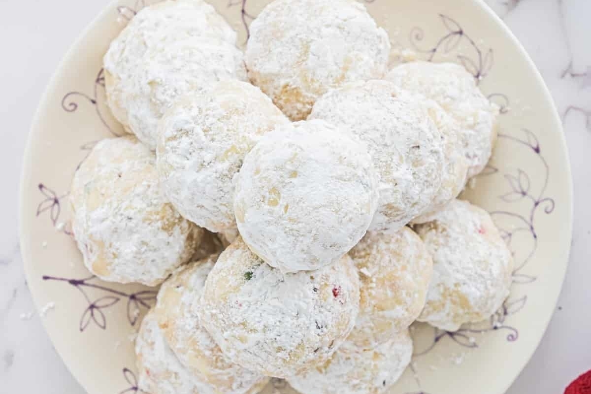 Peppermint powdered sugar cookies on a plate with red roses.