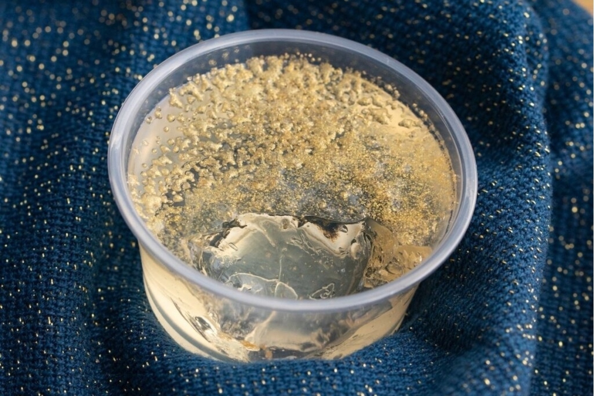 A plastic cup filled with sand on a blue cloth at a New Year's eve party.