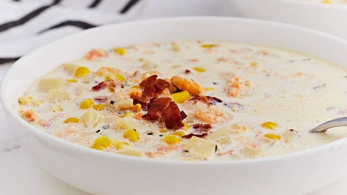 Two bowls of chowder with bacon and corn.