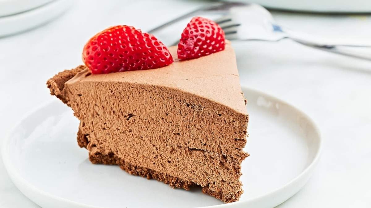 A slice of chocolate cheesecake, one of the best no bake desserts, elegantly presented on a white plate for this indulgent shared roundup.
