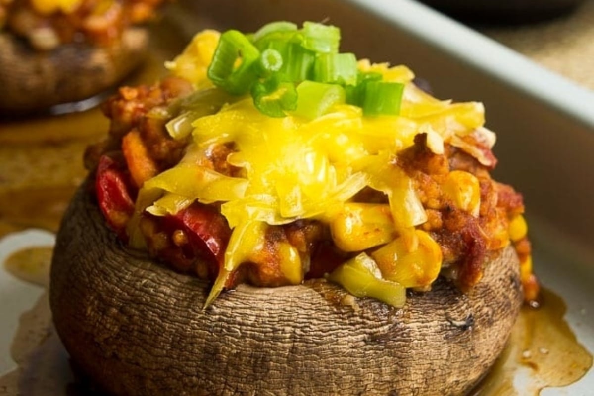 New Year's appetizer featuring stuffed mushrooms topped with chili and cheese.