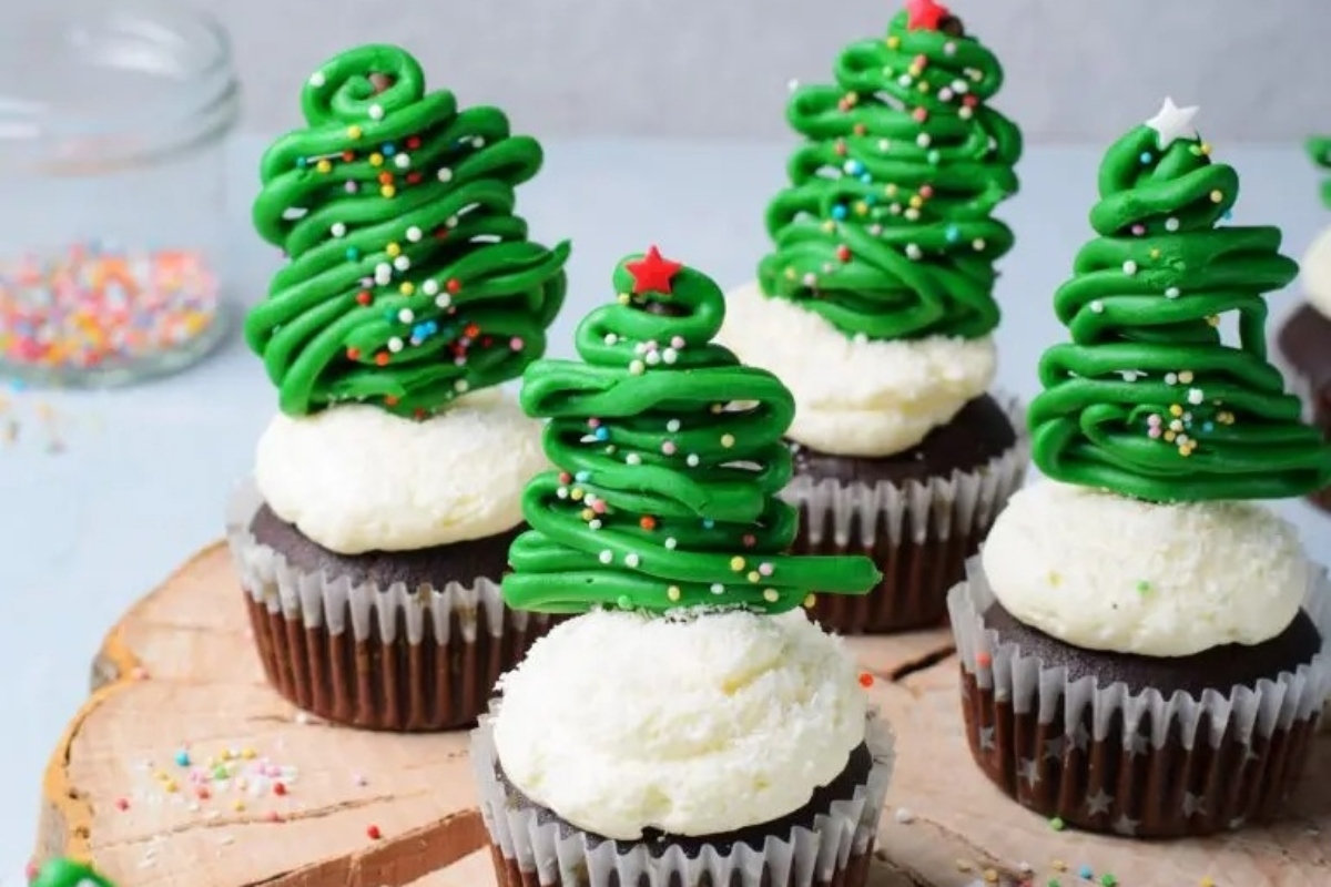 Christmas tree cupcakes on a wooden board.