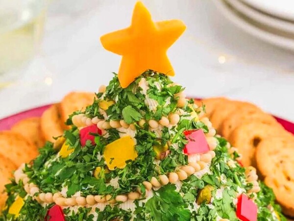 A festive cheese ball shaped like a Christmas tree, topped with a cheese star and served with crackers.