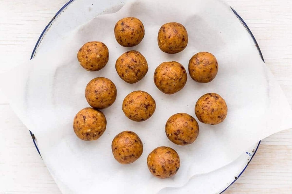 No-bake potato balls decorated on a plate on a wooden table.