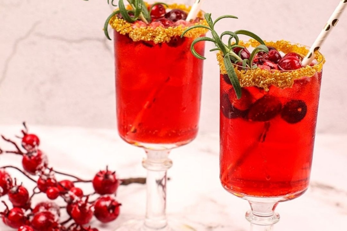 Two cranberry drinks with cranberry garnishes.