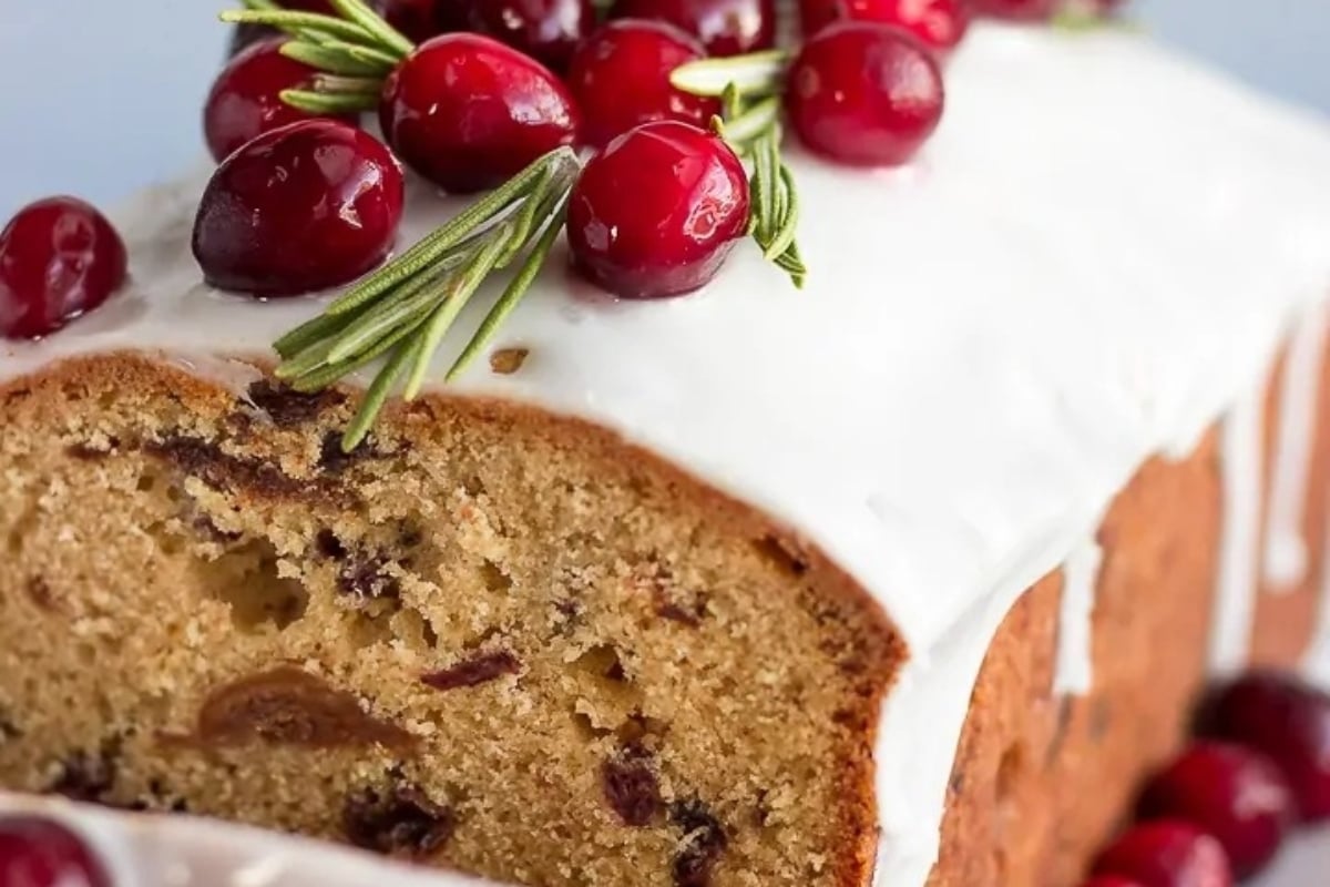 A festive slice of cranberry bread with tangy icing and tart cranberries.