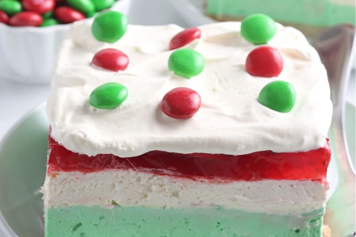 A slice of vibrant green, red and white ice cream cake on a plate.