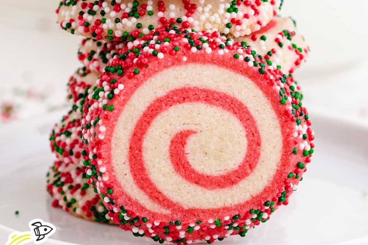 A stack of freezable Christmas cookies with sprinkles on top.