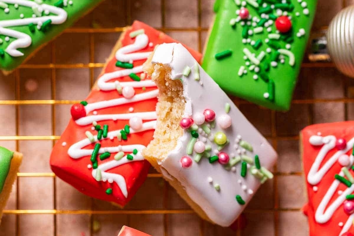 Christmas cookies with icing and decorations on a cooling rack.