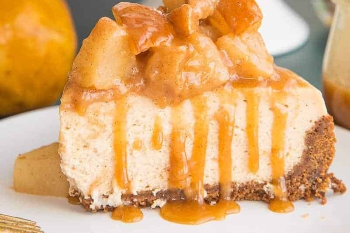 A decadent slice of apple pie cheesecake on a plate, perfect for a holiday dessert.