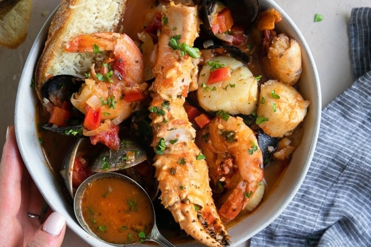A feast of seven fishes featuring a bowl of seafood stew with clams and mussels.