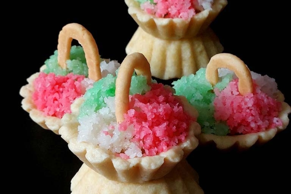 A group of small baskets filled with pink, green, and white icing.