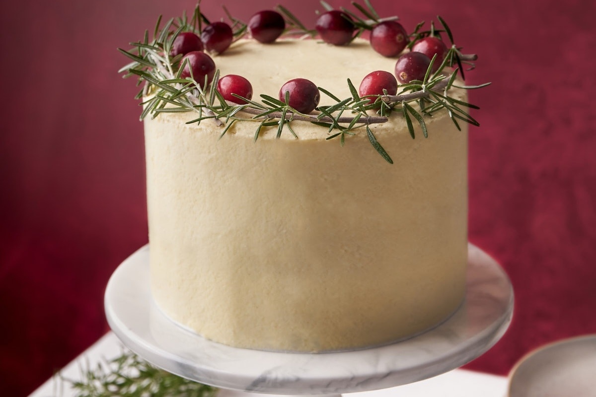 An exquisite Christmas cake adorned with fresh berries on top.