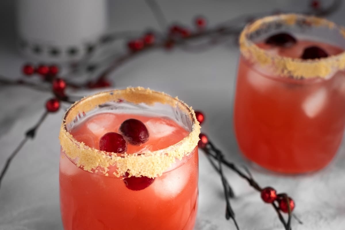         Two glasses of cranberry margarita on a table, showcasing delightful cranberry drinks.