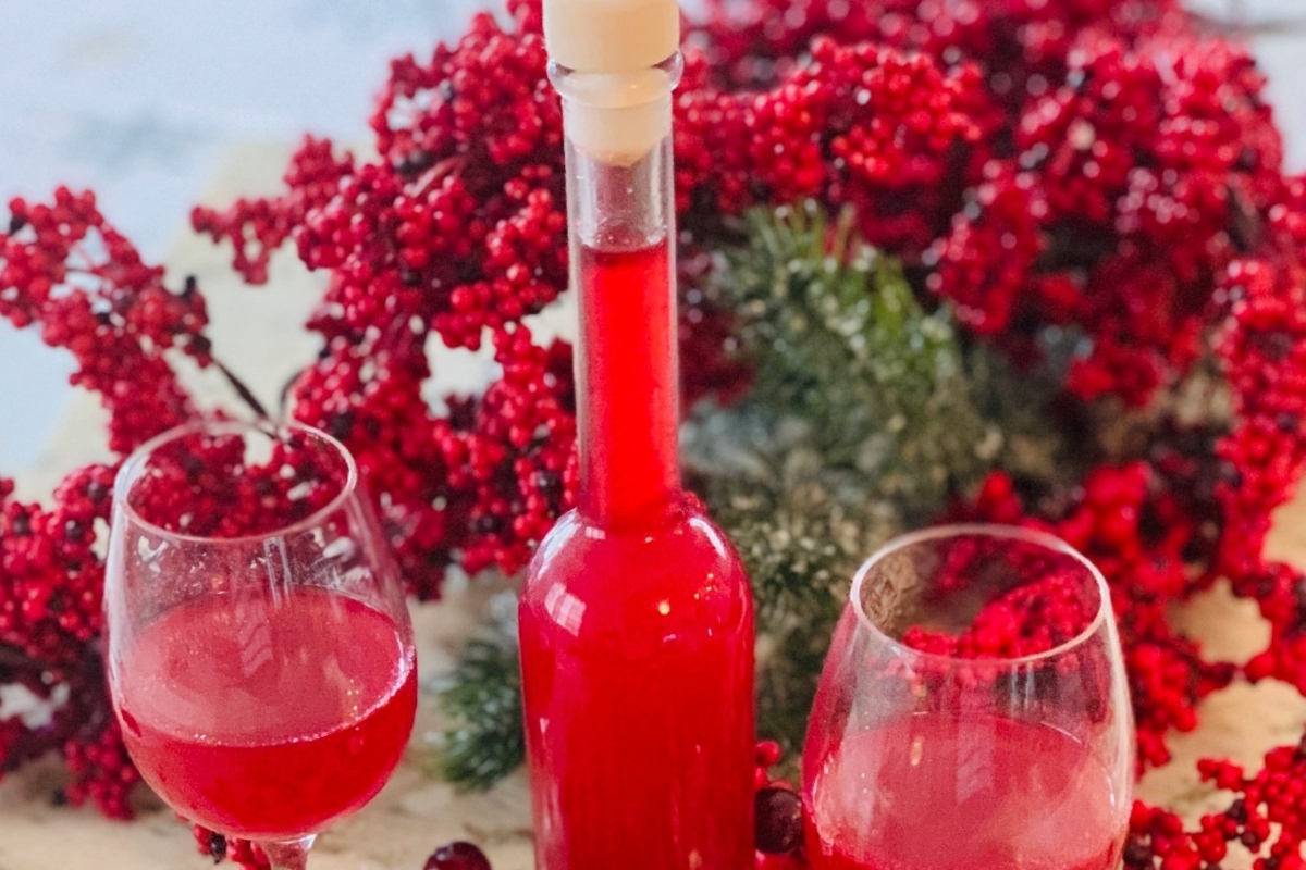 Red wine with cranberries on a table.