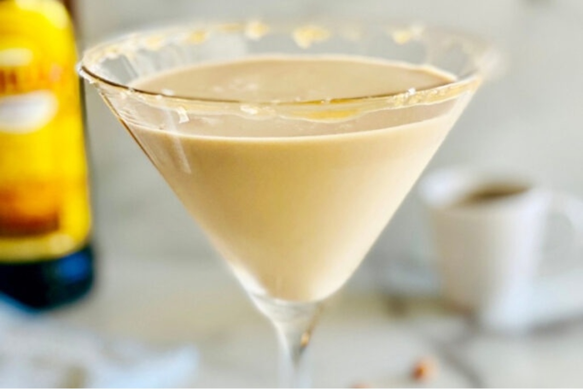 A festive New Year's Eve cocktail idea, featuring a martini in a martini glass paired with a bottle of bourbon.