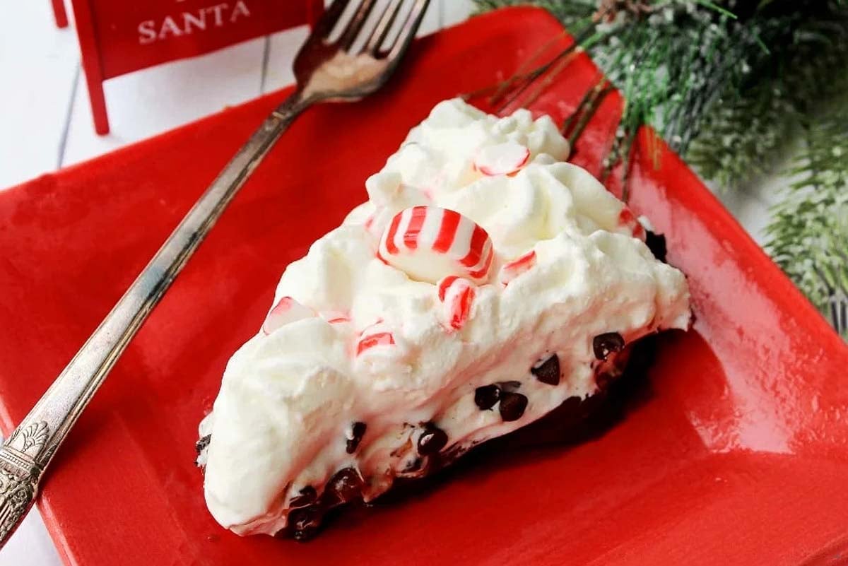 A slice of chocolate peppermint pie on a festive red plate.