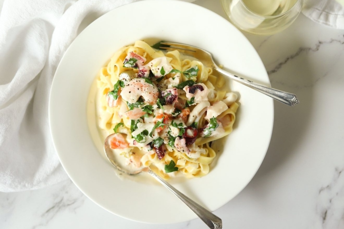 New Year's Eve Meal Idea: A delectable white plate featuring a delightful combination of pasta and shrimp.