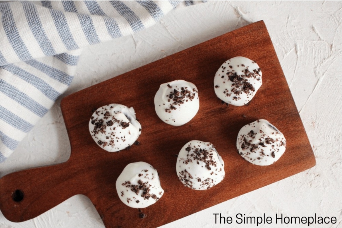 A wooden cutting board adorned with delicious no bake Christmas desserts, such as cookies.