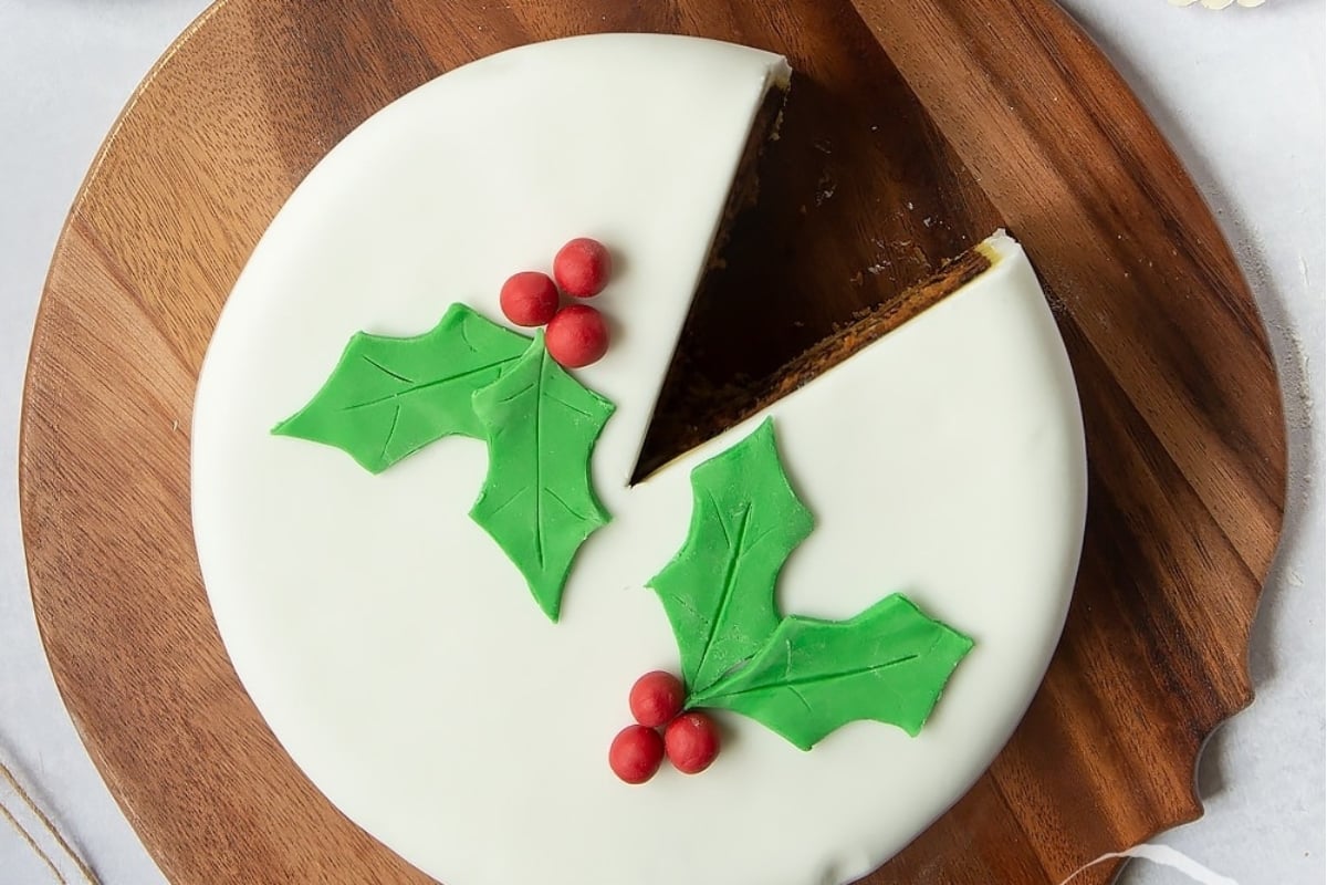 A festive Christmas cake with a slice cut out.
