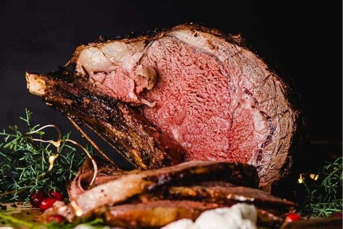 A large roast, perfect for New Year's dinners, is sitting on a cutting board.